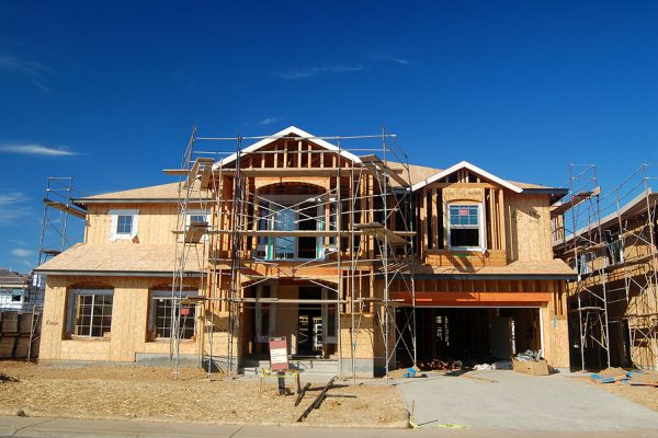 unfinished house with a for sale sign in front